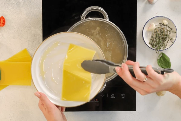 Через 5 минут листы лазаньи выложить на блюдо, предварительно смазанное маслом.
