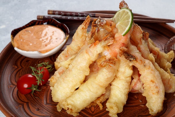 Готовые креветки выложить в форме "костра", украсить дольками лайма, подать с острым соусом.