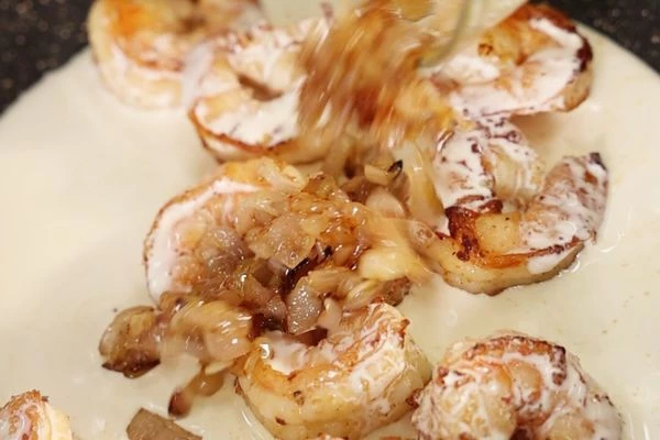 Когда коньяк выпарится поджечь и ввести сливки, орегано и жаренный лук.