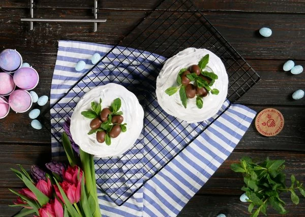 Выпекать в разогретой до 180 градусов духовке 30-35 минут. Готовым куличам дать полностью остыть. Намазать глазурью. Оформить шоколадными яйцами и мятой.