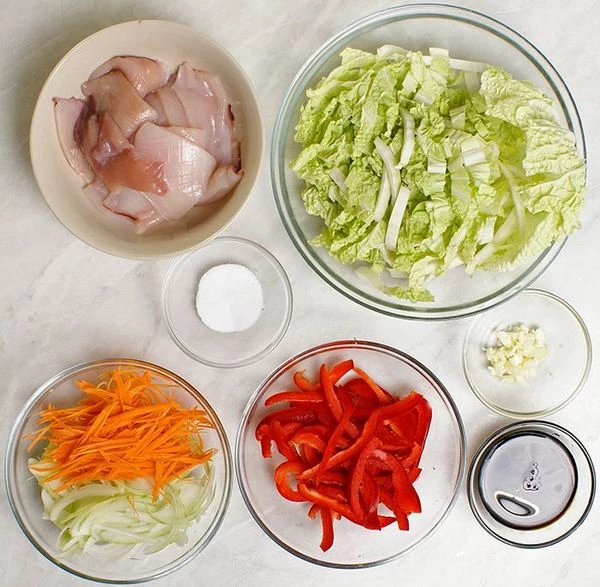 Капусту китайскую нарезать широкой полоской. Морковь, перец красный и лук нарезать тонкой соломкой. Чеснок мелко порубить.