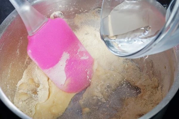 Влить воду, хорошо размешать силиконовой или деревянной лопаткой.