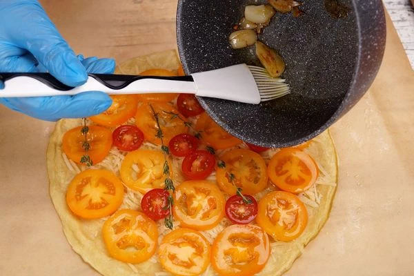 Сверху положить помидоры, смазать медовой глазурью и чесночным маслом, посыпать веточками тимьяна. 