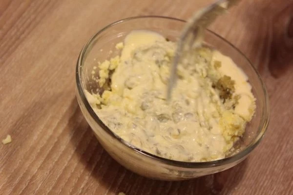 Желток растереть до состояния пасты. Смешать майонез, огурцы, каперсы и желток.