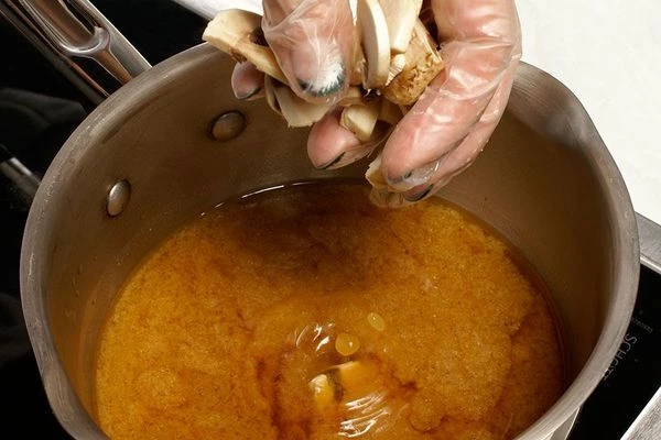 В кастрюлю налить бульон, добавить шампиньоны и проварить 5-7 минут.