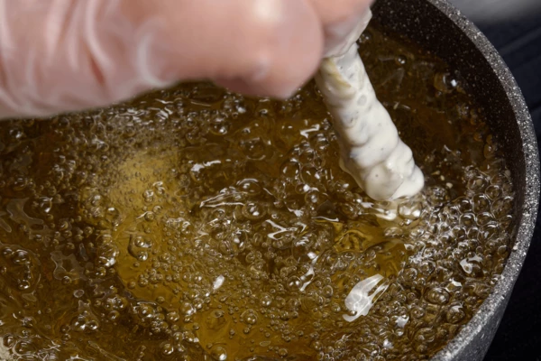 Креветки по 1 штуке обмакнуть в кляр, затем аккуратно за хвостик опускать во фритюр, слегка водя из стороны в сторону, чтобы кляр получился в виде воздушной корочки. Жарить 1-2 минуты до золотистого цвета.