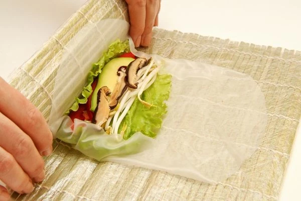 Затем свернуть плотно ролл, прижав ковриком начинку.

