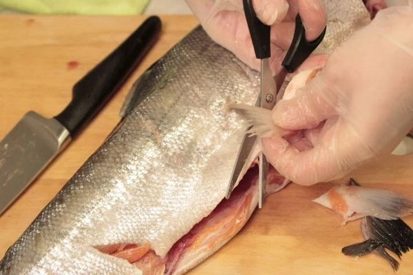 Рыбу разморозить на нижней полке холодильника. Промыть, обсушить бумажным полотенцем. У кеты отрезать голову. Обязательно удалить жабры.Разрезать вдоль хребта пополам. Срезать плавники и хвост. Использовать их для бульона.