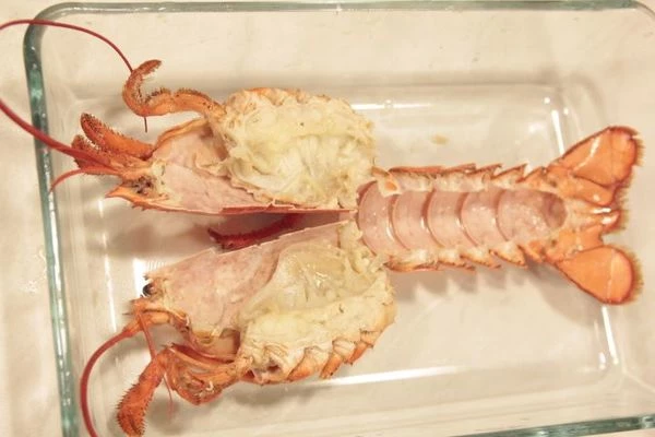 Сливочное масло растопите, добавьте туда мелко натертый чеснок и порубленную зелень. Мясо лобстера нарежьте небольшими кусочками. Перемешайте с получившимся маслом. За фаршируйте панцирь. Посыпьте натертым на мелкой терке сыром.