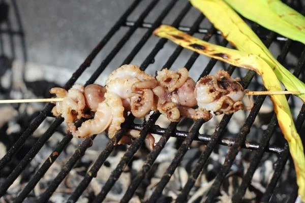   Нанизать подготовленные морепродукты на деревянные шпажки, украсить помидорами черри, кубиками перца и кольцами лука порея.