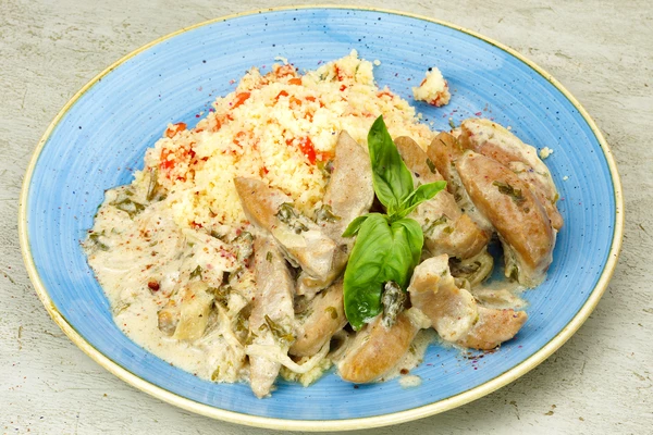 На тарелку выложить горкой гарнир из кускуса с помидорами, рядом тушеные в сметане семенники, украсить зеленью. Изысканный деликатес готов!