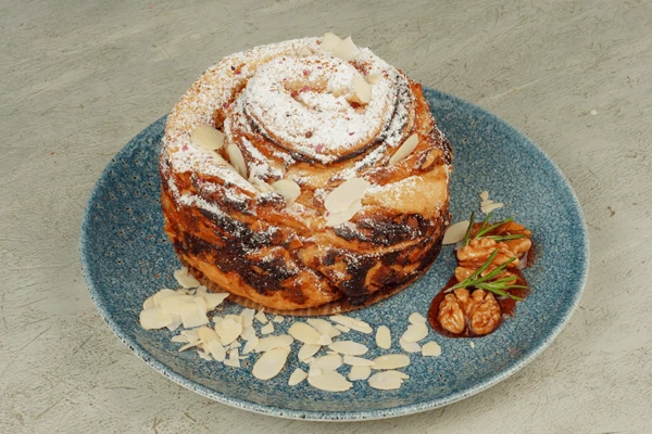 Готовый пирог украсить сахарной пудрой и орехами.