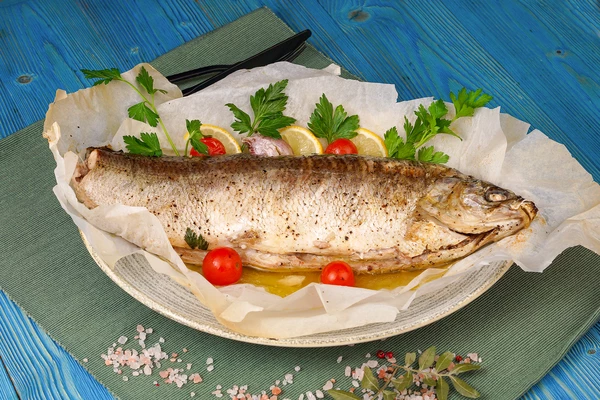 Готовую рыбу аккуратно раскрыть сверху (про скобы не забудьте и горячий пар), украсить дольками лимона, помидорами черри и веточками зелени.