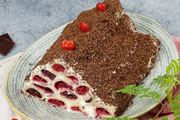 Украсить сушеной вишней. Нарезать настоявшийся торт на порции.