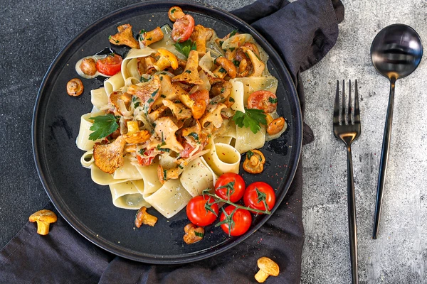 Оформить блюдо: в центр горкой выложить пасту, сверху томленые в соусе грибы, украсить зеленью. Как всегда — просто, быстро и вкусно! 
