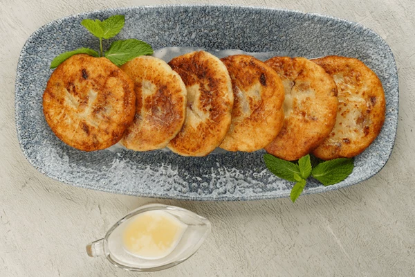 Украсить веточкой мяты. Подать с сгущенным молоком, сметаной или джемом. 