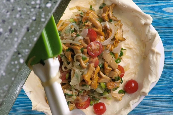 Выложить часть заливки, затем луково-грибную начинку.