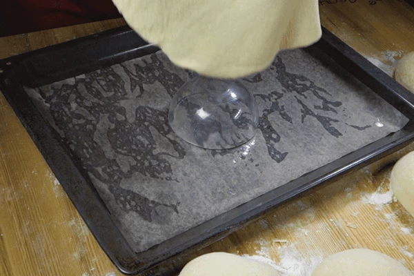 На противень с пергаментом поставить чашку, сверху на чашку уложить раскатанный пласт теста.