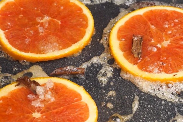 Дольки апельсина прогреть в сиропе 2-3 минуты.