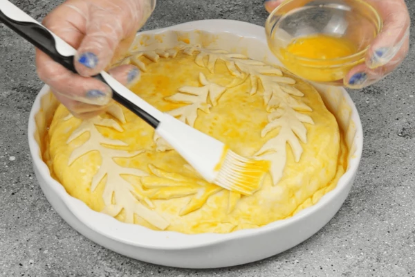 Смазать взбитым желтком. Часть теста можно оставить на украшение, вырезать рыбок, водоросли и др. — на ваше усмотрение. Смазанный пирог оставить на 10-15 минут в теплом месте, чтобы поднялся.