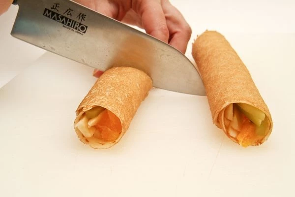 Затем приготовить еще один блинчик. Нарезать каждый рулет на 4-5 равных частей

 