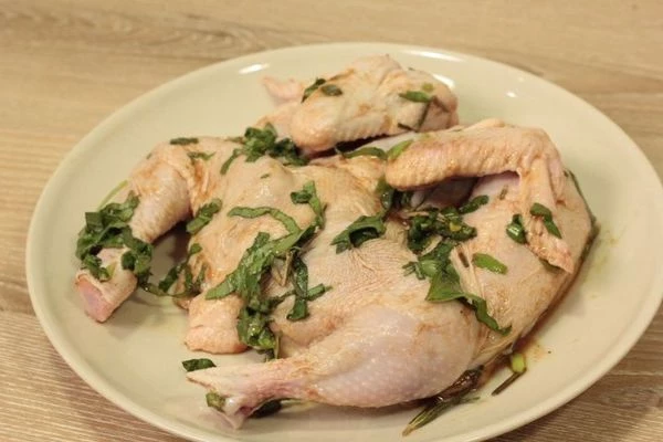 Цыпленка промыть, удалить оставшиеся перья, обсушить. Разрезать вдоль грудки, развернуть. Тушку цыпленка немного посолить, положить на 30 минут  в маринад.