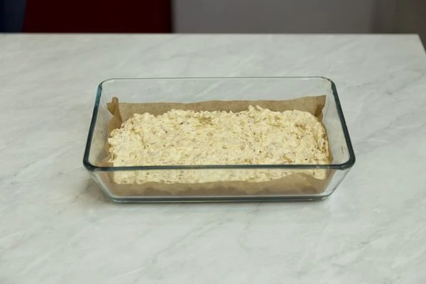 На противень положите лист пергаментной бумаги. Выложите на него тесто, разровняйте. 