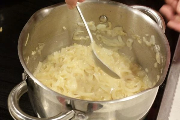 Лук обжарить в кастрюле с толстым дном на среднем огне на сливочном масле примерно 25 минут.