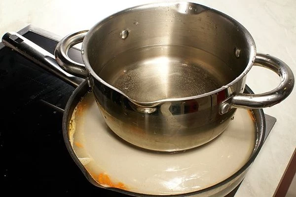 Накрыть долму тарелкой, чтобы сохранить форму, и поставить на средний огонь под пресс тушиться на 30-40 минут. Затем снять тарелку.