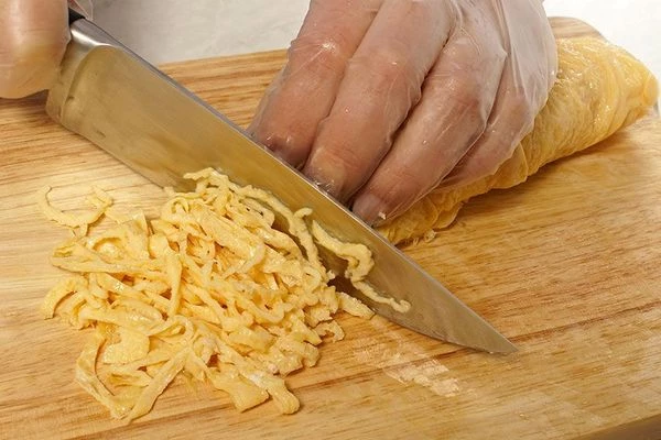 Яичные блинчики свернуть рулетом и нарезать тонкой соломкой