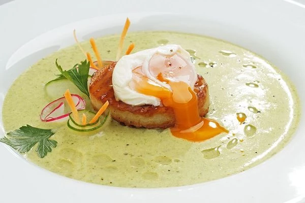 В центр тарелки выложить "башенку" из картофеля. Сверху положить яйцо (перед этим аккуратно снять пленку). По кругу налить крем-суп. Украсить свежими овощами.