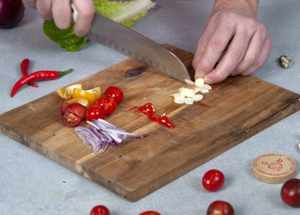 Чеснок мелко нарубить, красный лук нарезать мелкой соломкой, помидоры черри пополам, чили перец тонкими колечками. 