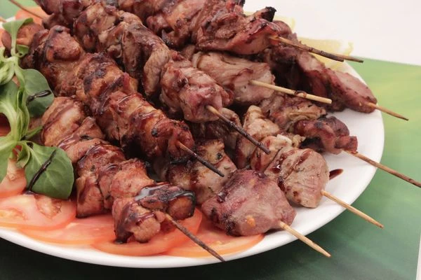 Украсить готовый шашлык свежими овощами и зеленью.