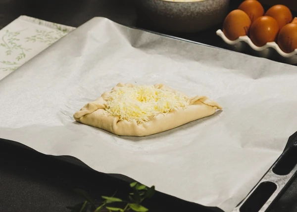 Защипать края, чтобы получилась лодочка. Внутрь лодочки выложить сыр. 