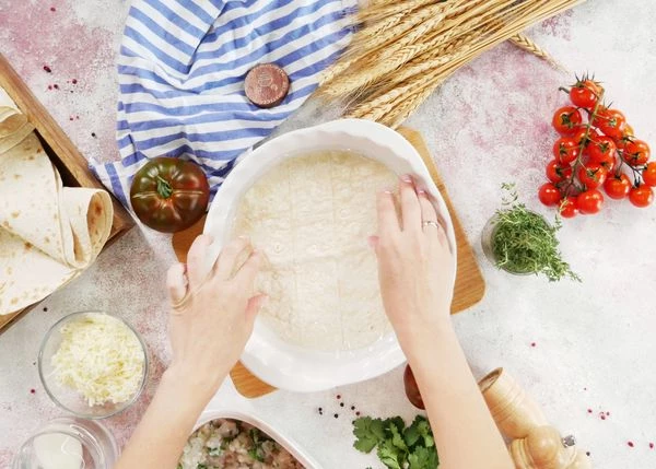 Лаваш смочить в воде, переложить на доску. 