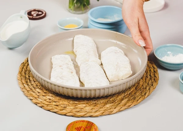 Рыбу выложить в форму для запекания. Сбрызнуть оливковым маслом. Запекать в разогретой до 180 градусов духовке в течение 15-17 минут.