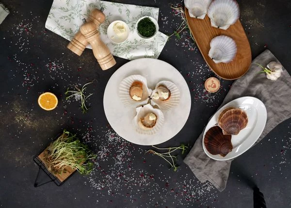 На каждый гребешок выложить кусочек сливочного масла.