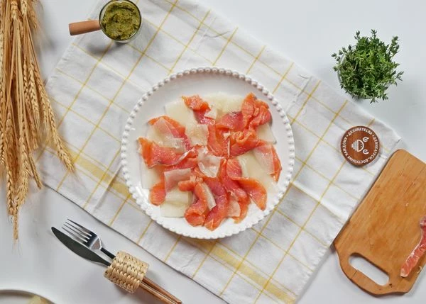 Семгу разморозить на нижней полке холодильника, нарезать тонкими ломтиками. Выложить на тарелку к дыне.