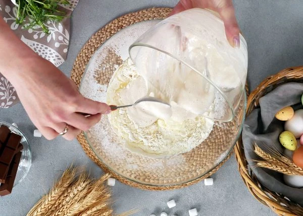 Затем добавить ванильную эссенцию, сливки, сахар разведенный в оставшемся количестве теплого молока и опару. Замесить эластичное мягкое тесто. 