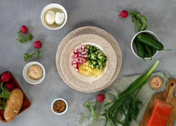 Картофель вымыть, отварить до готовности, очистить. Картофель, огурец и редис нарезать мелким кубиком. Выложить в тарелку для подачи.