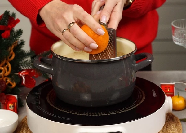 Добавить сок 2 мандаринов и немного цедры, выключить нагрев, перемешать.