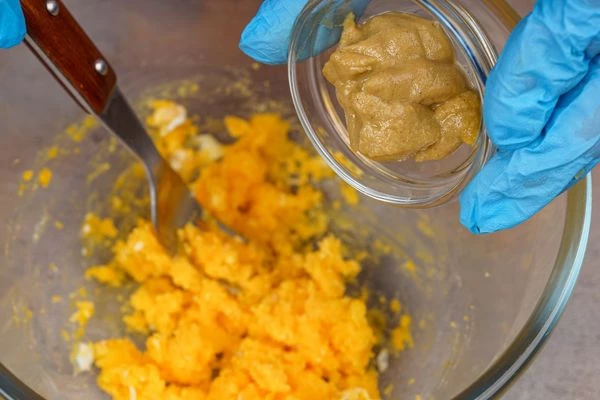 Желтки растереть вилкой, затем добавить горчицу и лимонный сок.