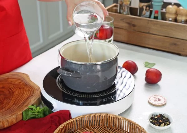 Нарезанный нектарины переложить в кастрюлю, добавить сахар и налить воду. 