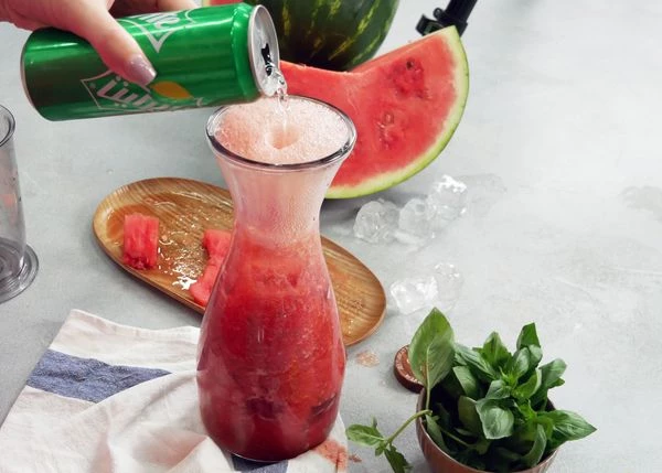 Перелить измельченную мякоть арбуза в кувшин. Добавить кубики льда, тоник или спрайт. Подавать к столу. 
