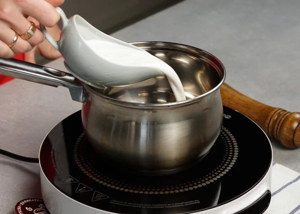 Для соуса влить в сотейник кокосовые сливки