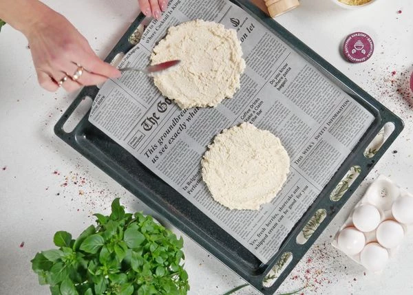 На противень застеленный пергаментом выложить шарик теста и разровнять руками до толщины 0,5-0,7 см. Повторить со вторым. 