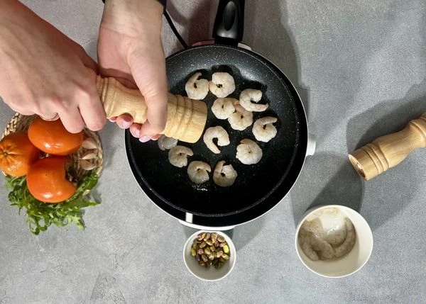 Креветки разморозить, обжарить на масле с чесноком, посолить.