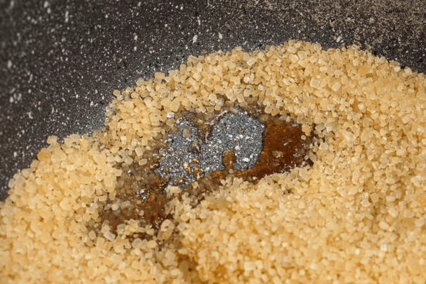 Пока булочки пекутся, готовим карамель. Для этого коричневый сахар (150 гр.) расплавить в сотейнике с высокими бортами до жидкого состояния.