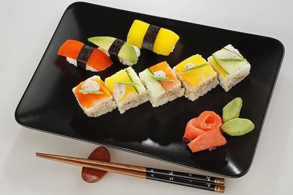 Выложить готовые суши на тарелку, украсить имбирем и васаби.