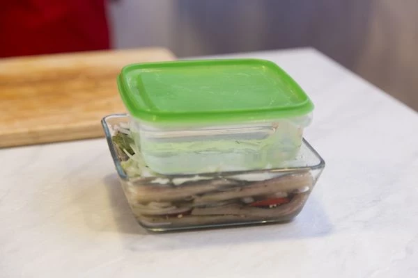 Установить на рыбу емкость с водой, в качестве пресса. Поставить в холодильник на 1-1,5часа.